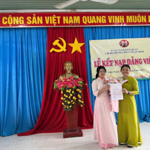 Bí thư chi bộ trao quyết định và hoa cho đồng chí đảng viên mới